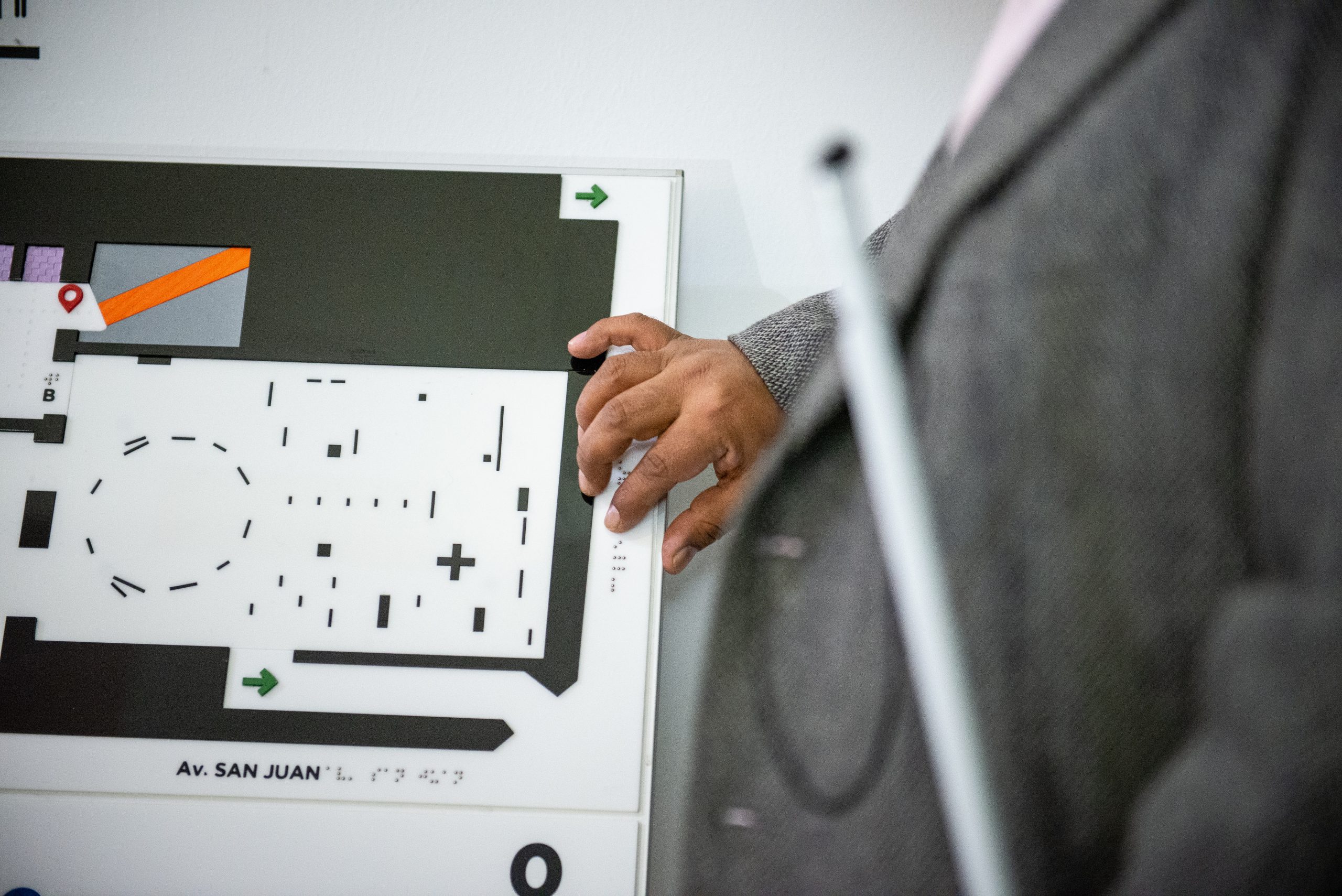 Imagen muestra persona leyendo el braille en el plano háptico del Museo Moderno.