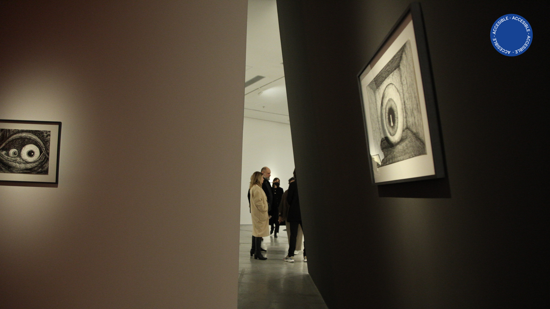 La foto muestra una sala del segundo piso del Moderno, en la que se encuentran personas apreciando la exhibición Pupila, de Eduardo Basualdo