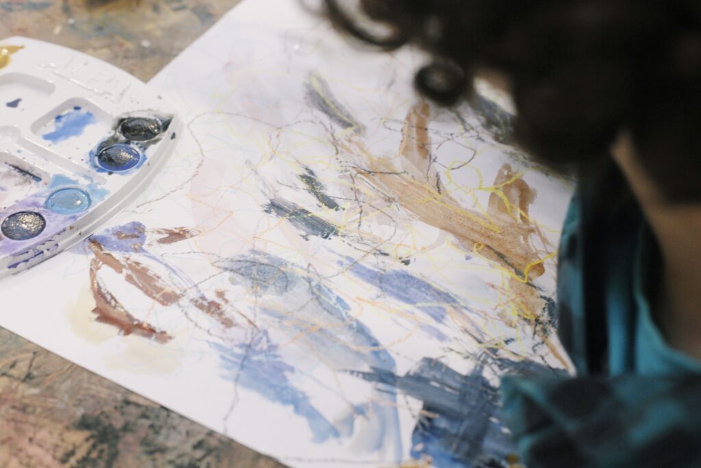 Fotografía muestra jóven pintando con acuarelas