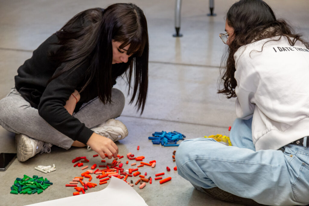 Jóvenes participan en un taller de arte, creando y compartiendo en comunidad.