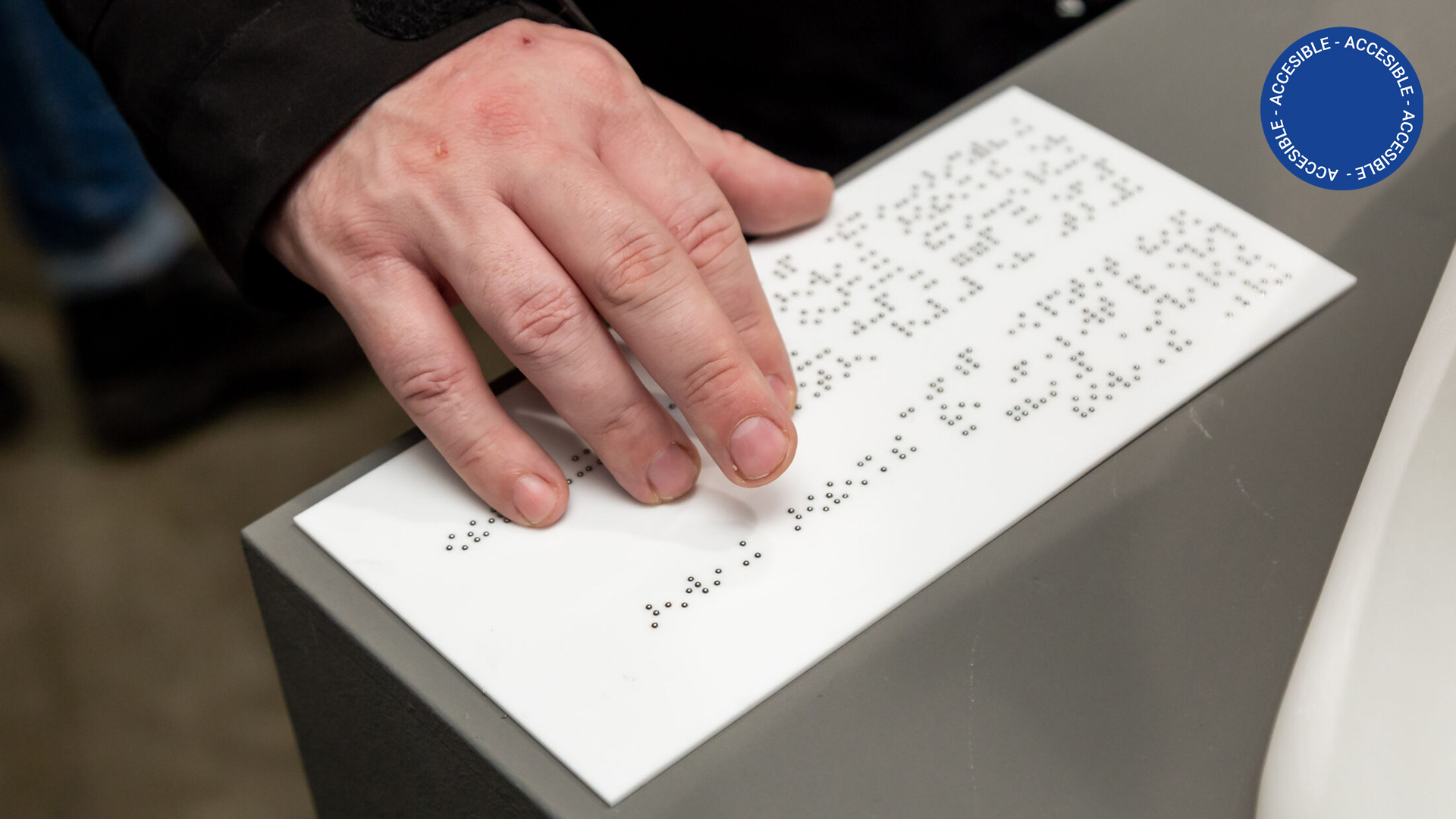 En la imagen se observa una mano leyendo código braille