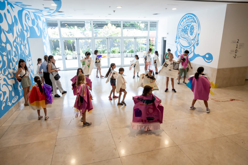 En la fotografía a color un grupo de niños y niñas participan de una actividad en el hall del Museo Moderno