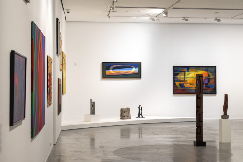 En la foto a color, la se observan un conjunto de obras de la exposición "Moderno y MetaModerno: Edición 70 Aniversario ", entre ellas, una escultura de Martín Blaszko