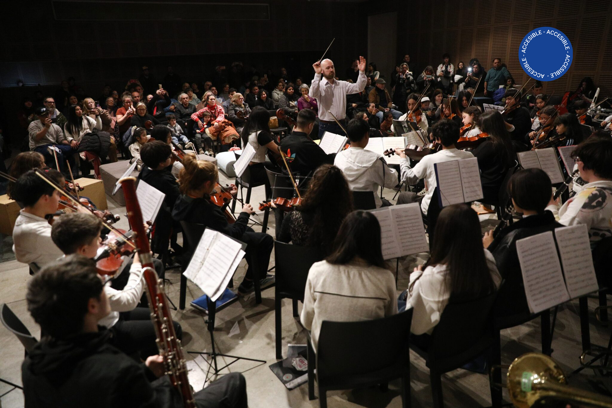 La foto muestra una de las Orquestas Infantiles y Juveniles de la Ciudad junto a su público en el Auditorio.