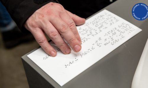 En la imagen se observa una mano leyendo código braille